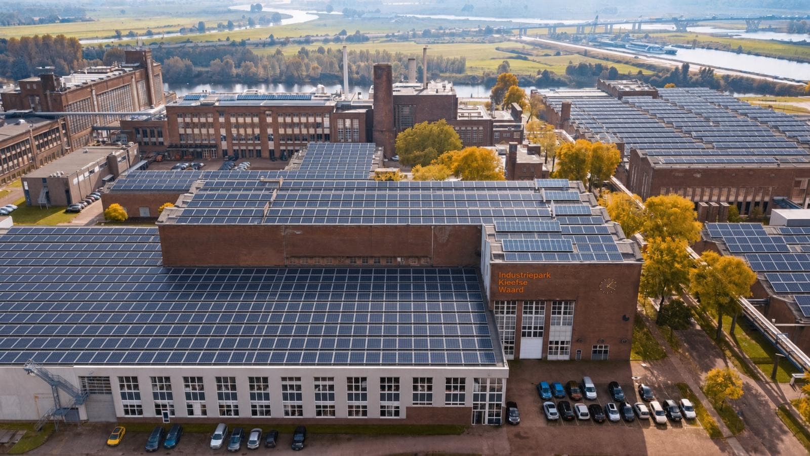 Aerial view of an industrial park on the Nederrijn near Arnhem, its hall roofs covered with solar modules